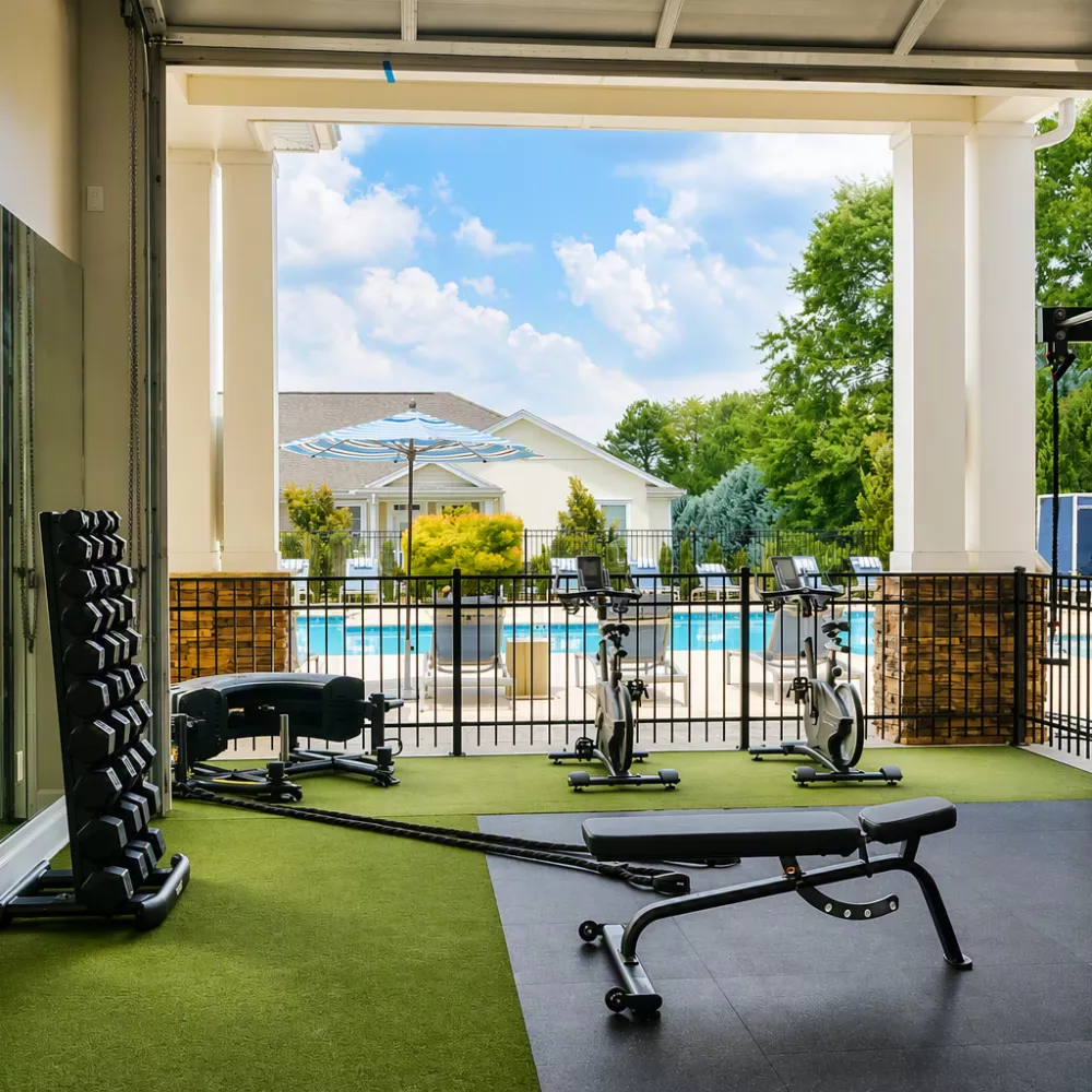 Fitness Center with weights, spin bikes, and a swimming pool view
